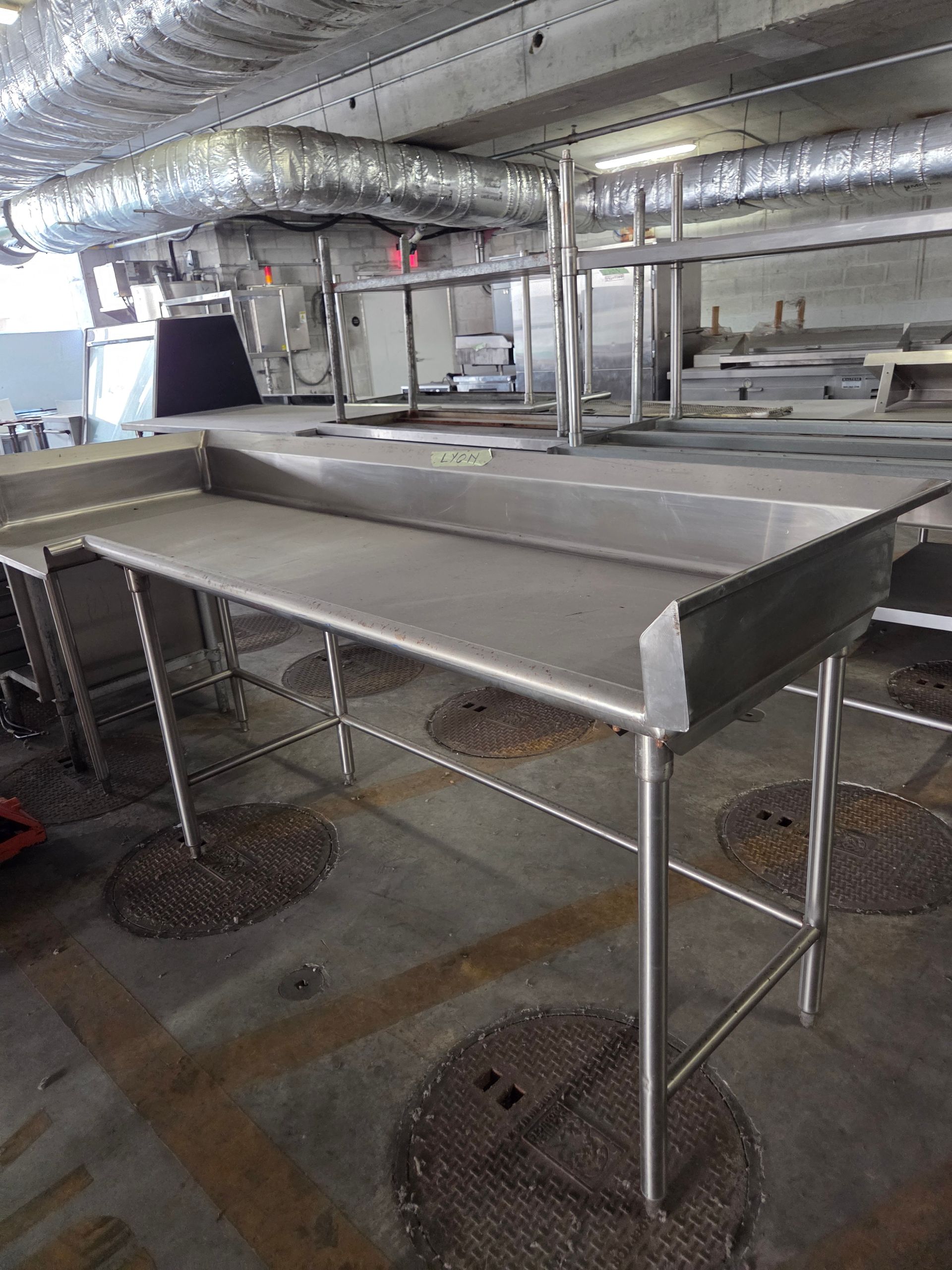 Stainless steel kitchen prep tables in a commercial kitchen.