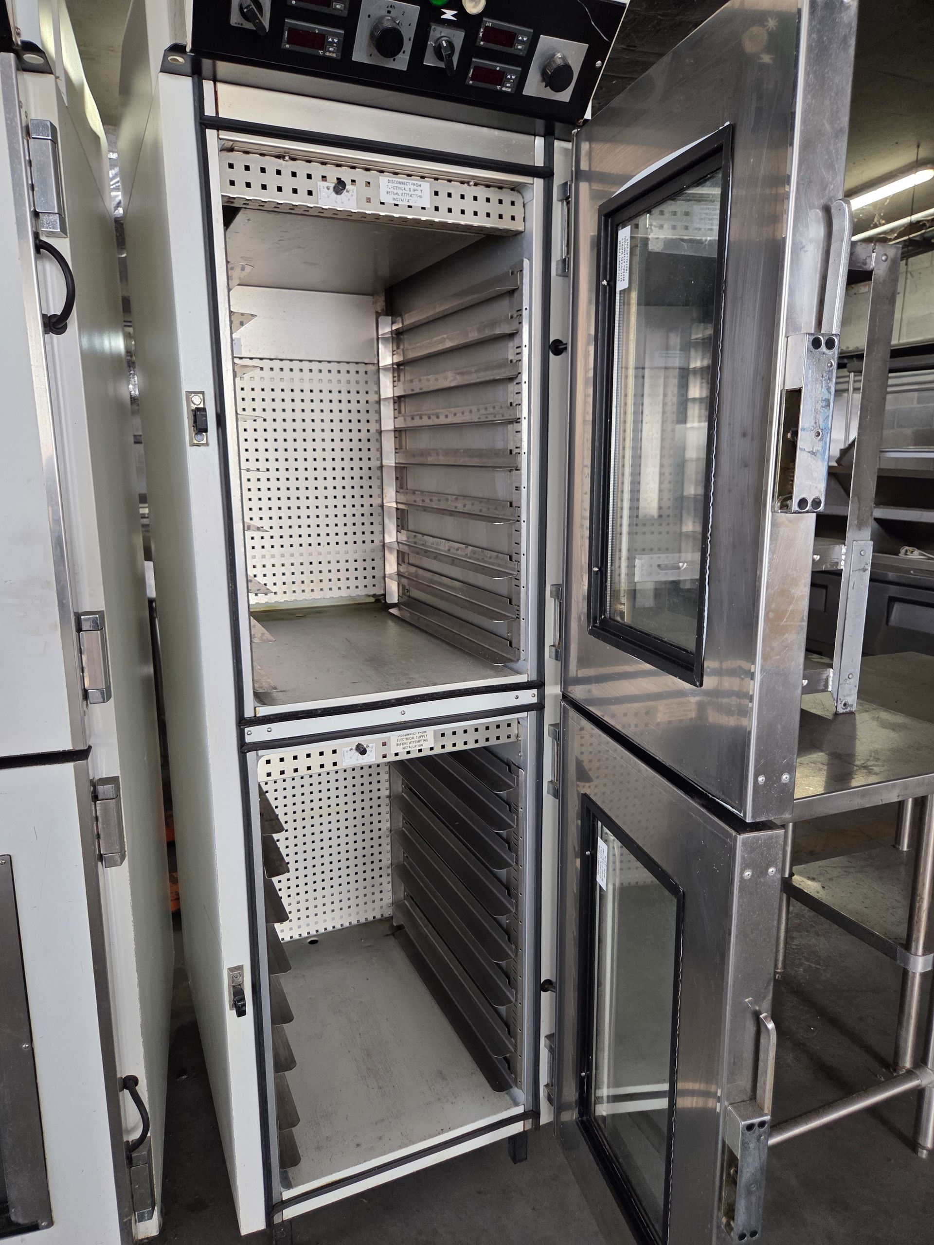 Commercial stainless steel oven with open doors, multiple racks, and control panel.