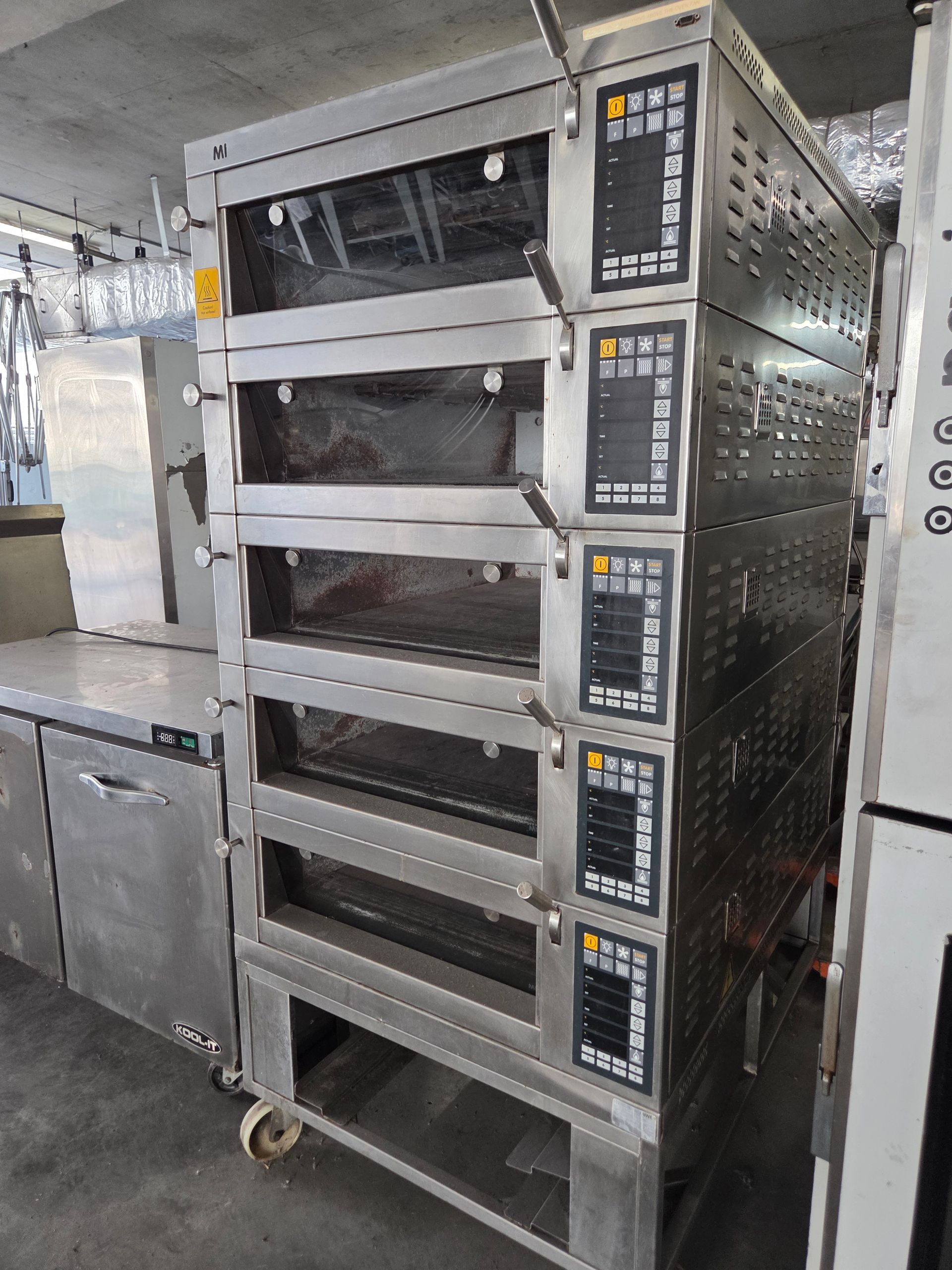 Stack of stainless steel commercial ovens, each with a digital control panel and viewing window.