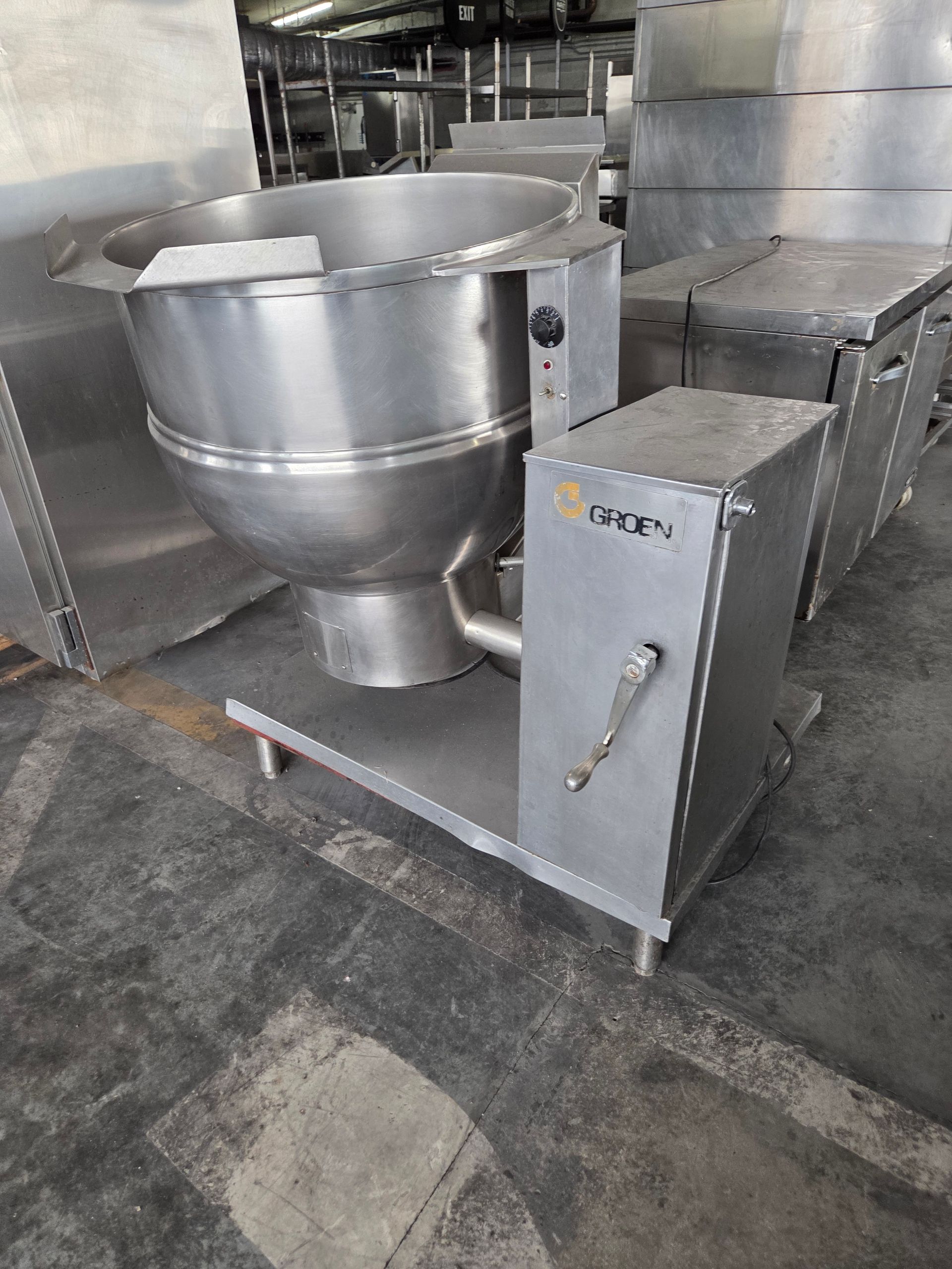 A large stainless steel commercial tilting braising pan in a kitchen setting.