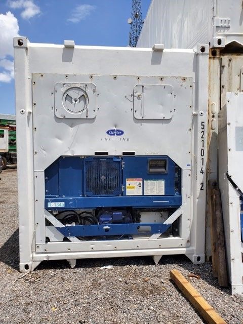 White and blue refrigerated shipping container, Carrier brand, outdoors.