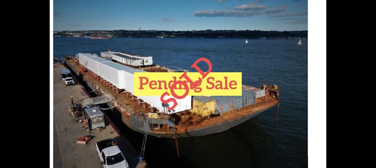 A barge with containers in a harbor marked 