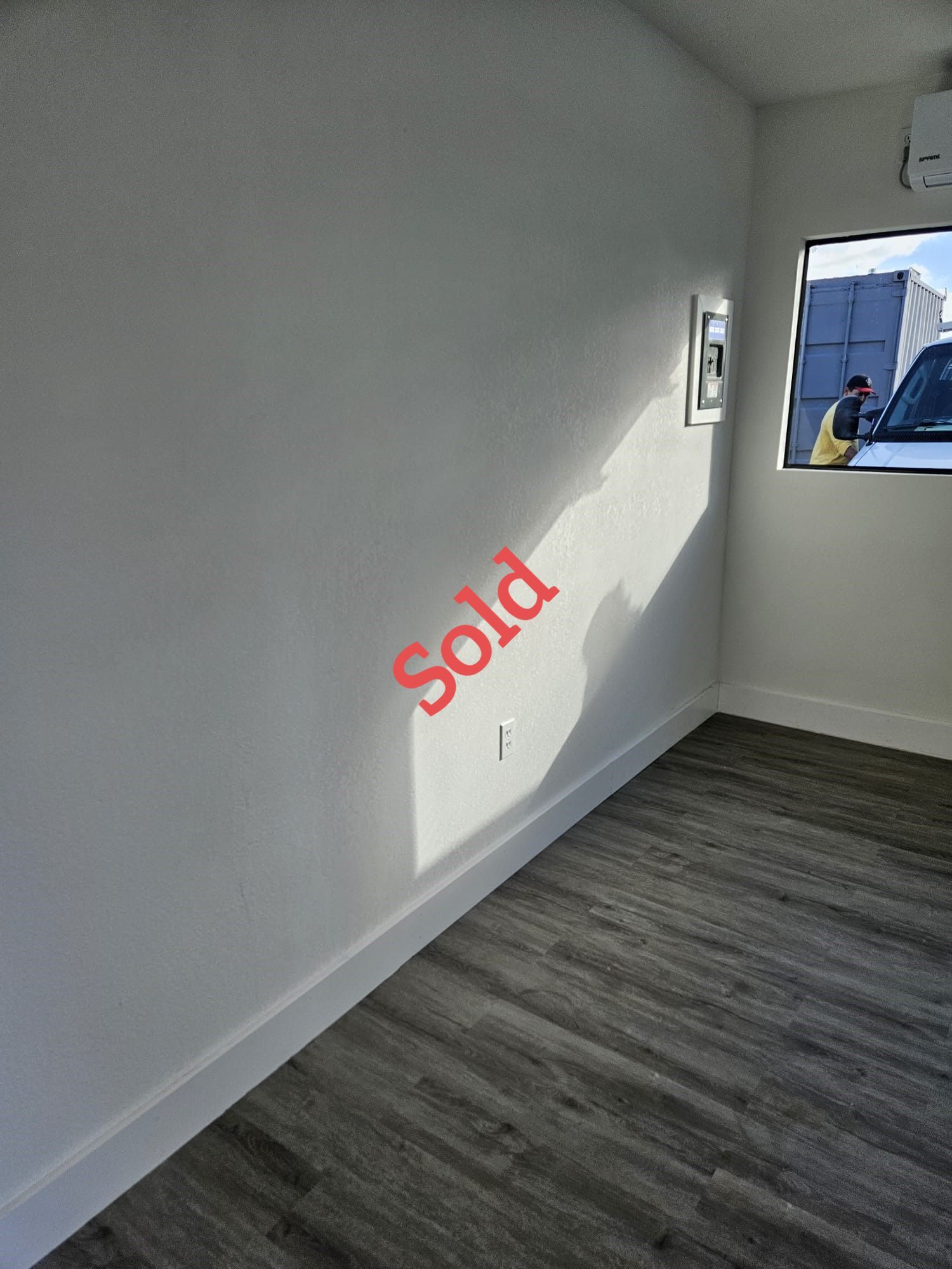 Empty room with gray wood-look floor, white walls, and 