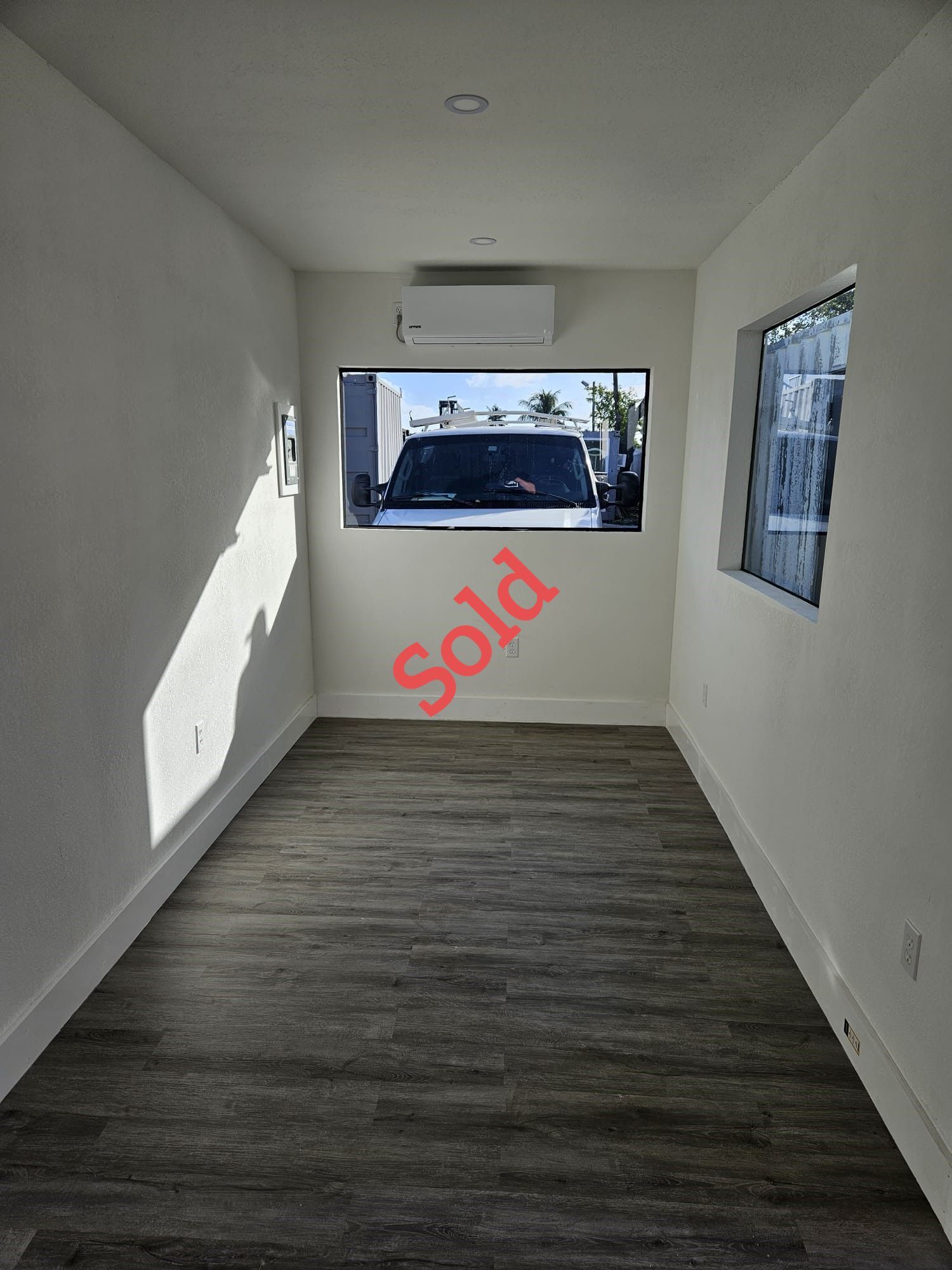 Interior view of a narrow room with a large window showing a 