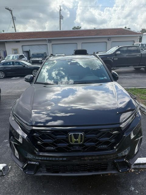 Dark gray Honda SUV parked in front of a building with a reflection of clouds on the windshield.