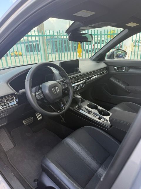 Interior of a gray Honda Civic. Black seats and dashboard, steering wheel visible.