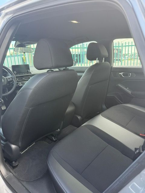 Rear interior view of a gray car with black seats; visible front and back seats.