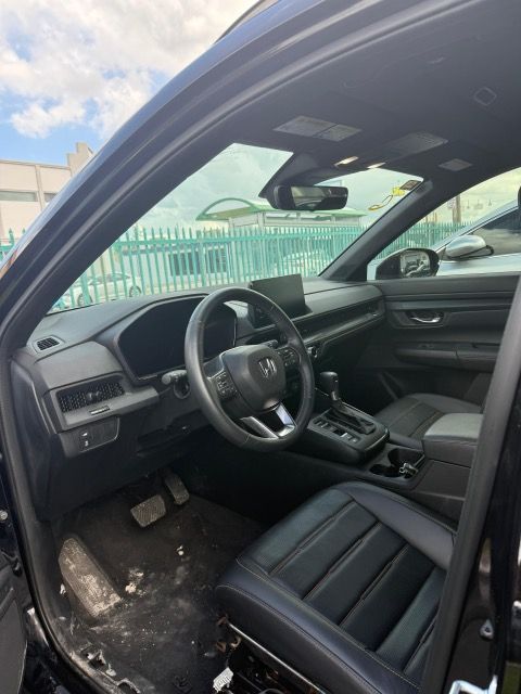 Interior of a black Honda CRV, showing steering wheel, dashboard, and driver's seat.