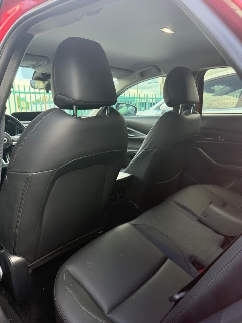 Rear interior of a car with black leather seats and headrests.
