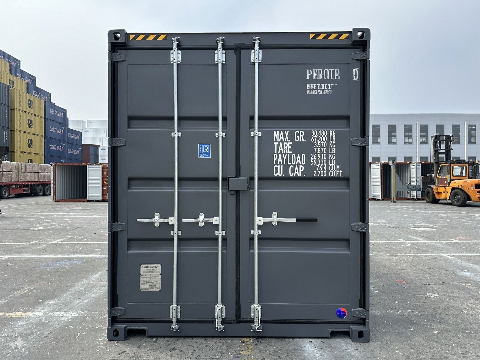 Dark gray cargo container in a yard, ready for transport.