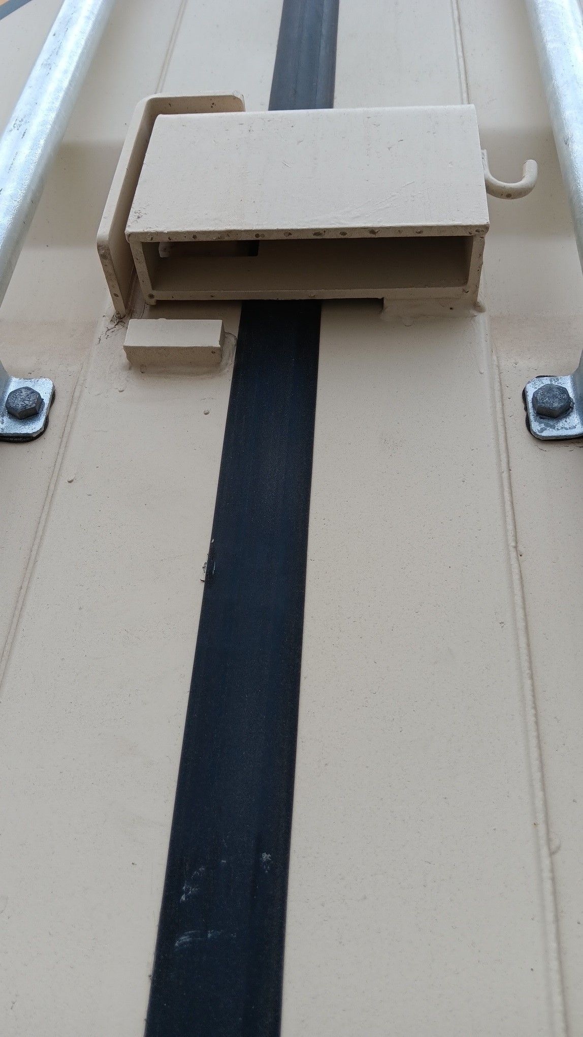 Tan metal container latch and black stripe.