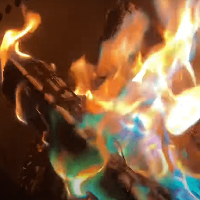 Burning logs with vibrant green, blue, and orange flames.