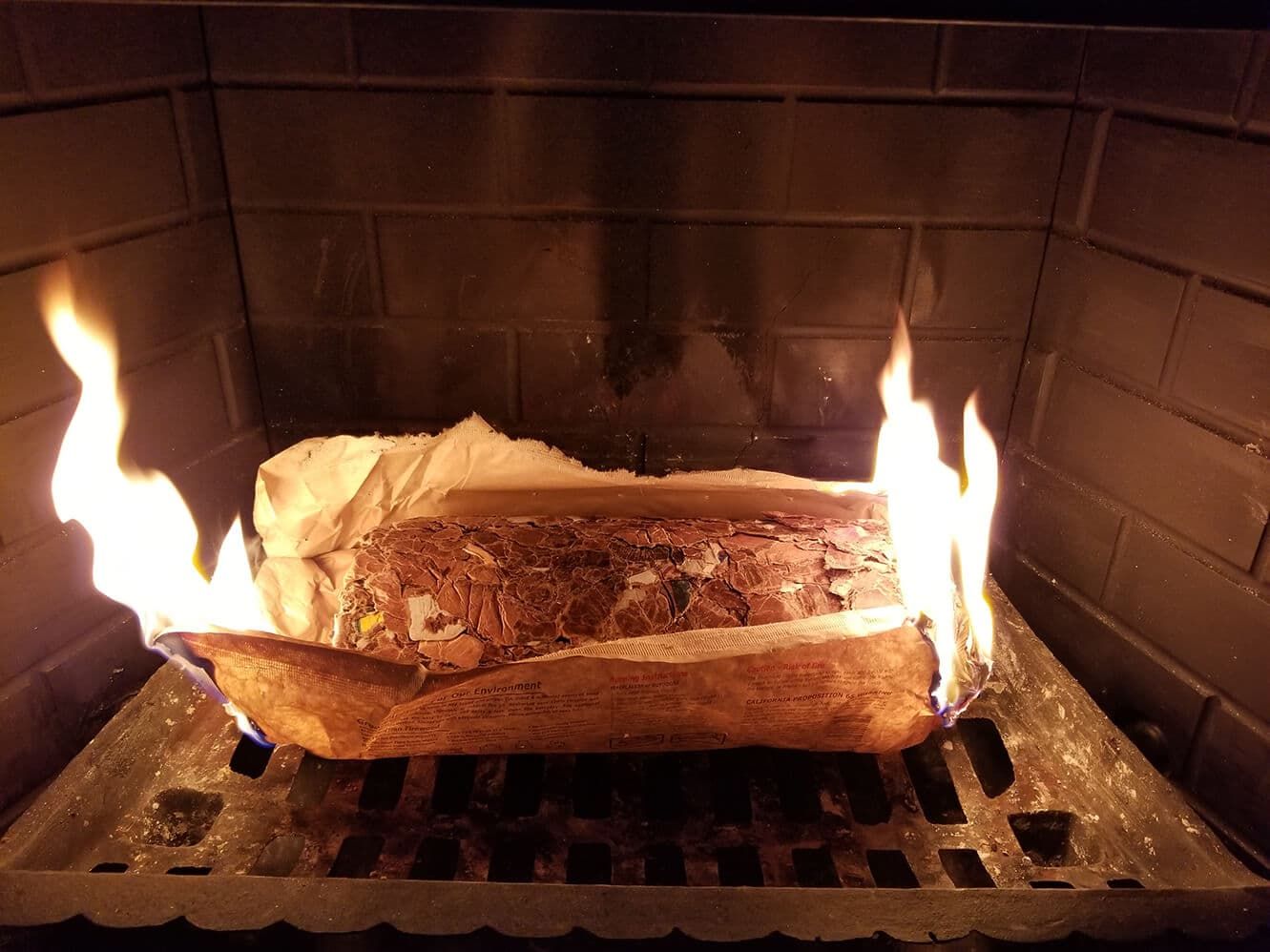 An EnviroLog open paper wrapper burns in a fireplace