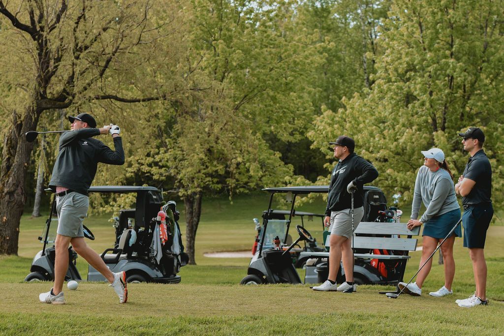 A group of people are playing golf on a golf course.
