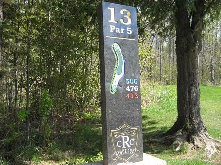 A sign for the 13th par 5 of a golf course
