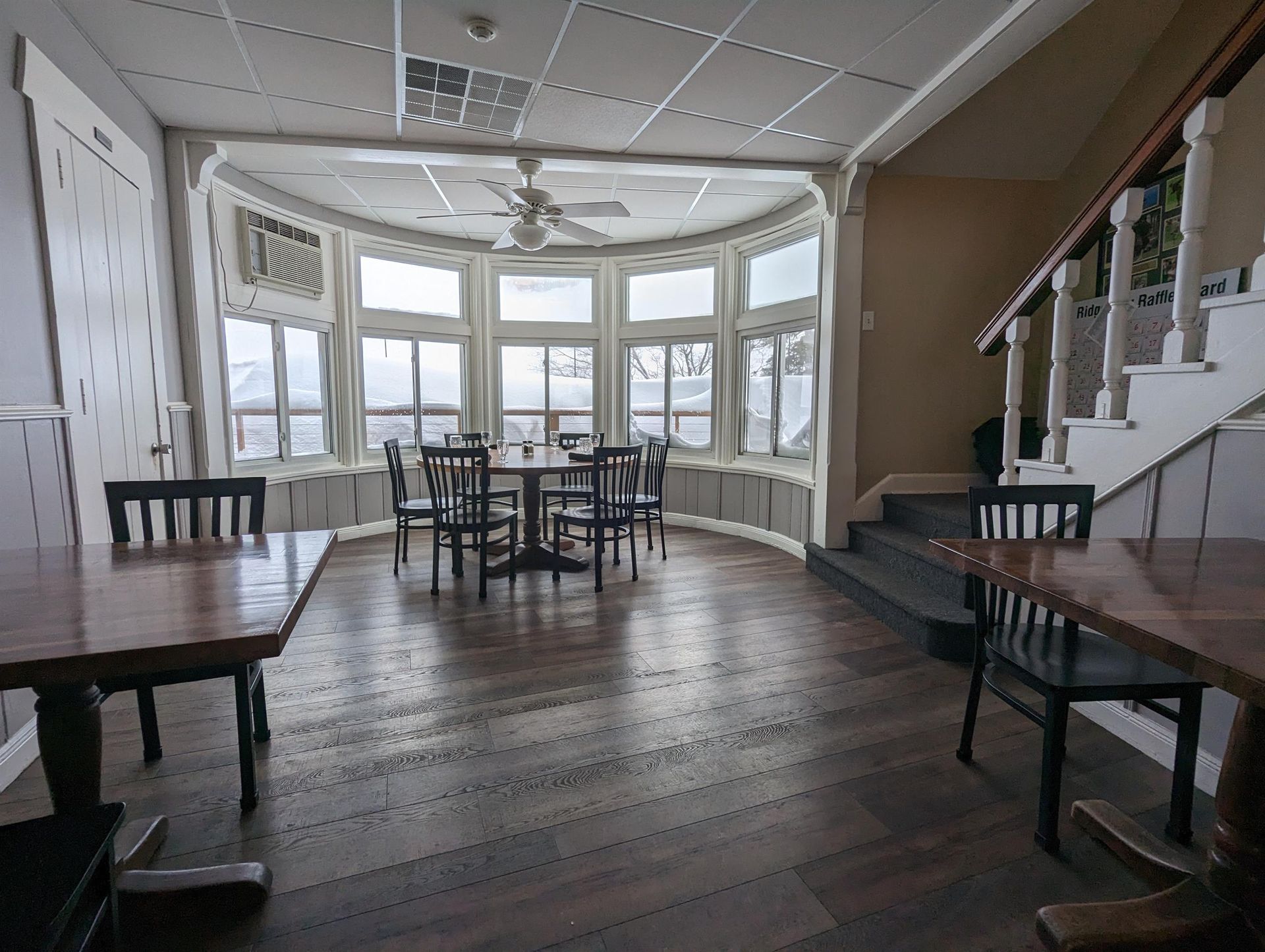 A large room with tables and chairs and stairs
