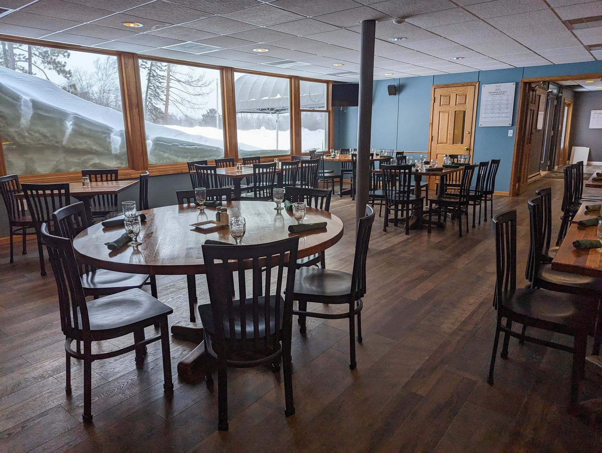 A restaurant with tables and chairs and a large window.