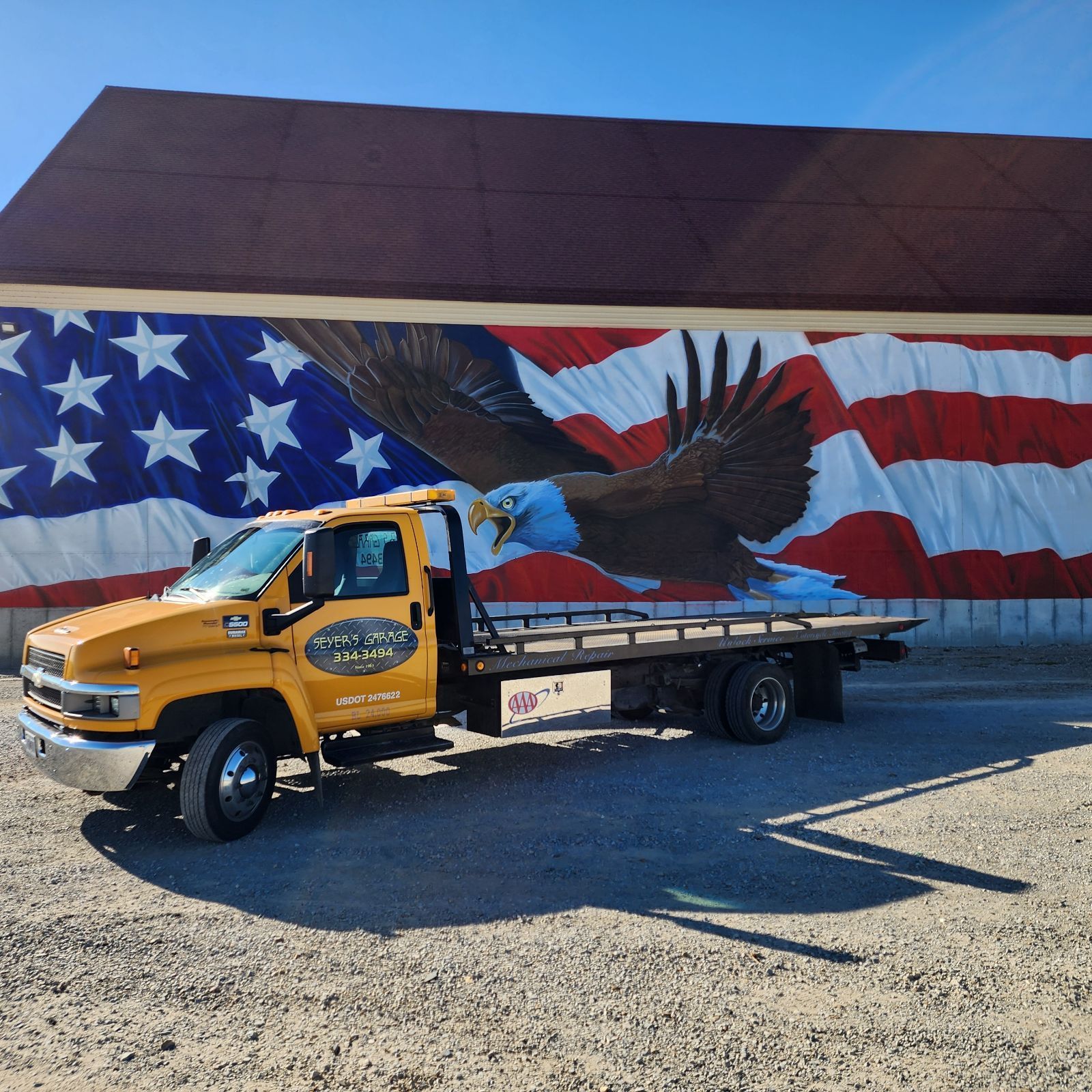 tow truck in front of american flag | Seyer's Garage