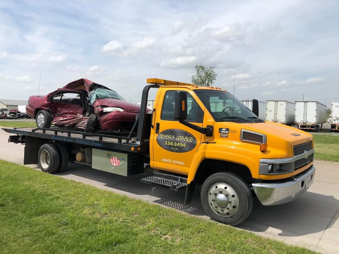 tow truck with wrecked vehicle on back | Seyer's Garage