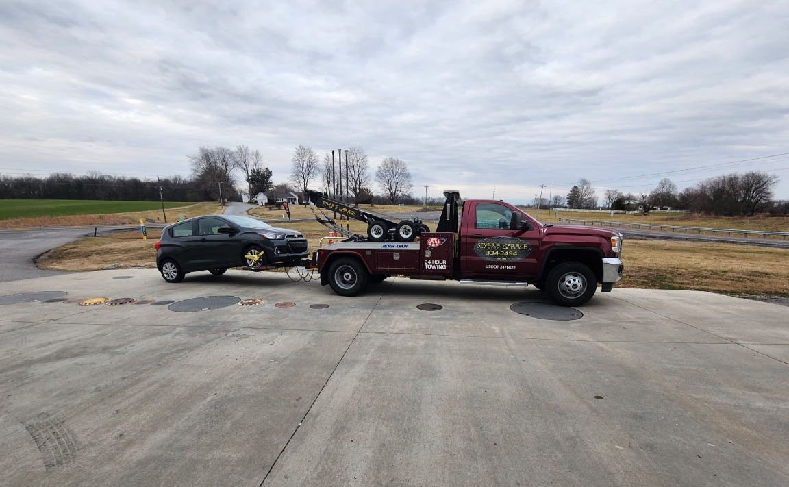 tow truck towing a sedan | Seyer's Garage