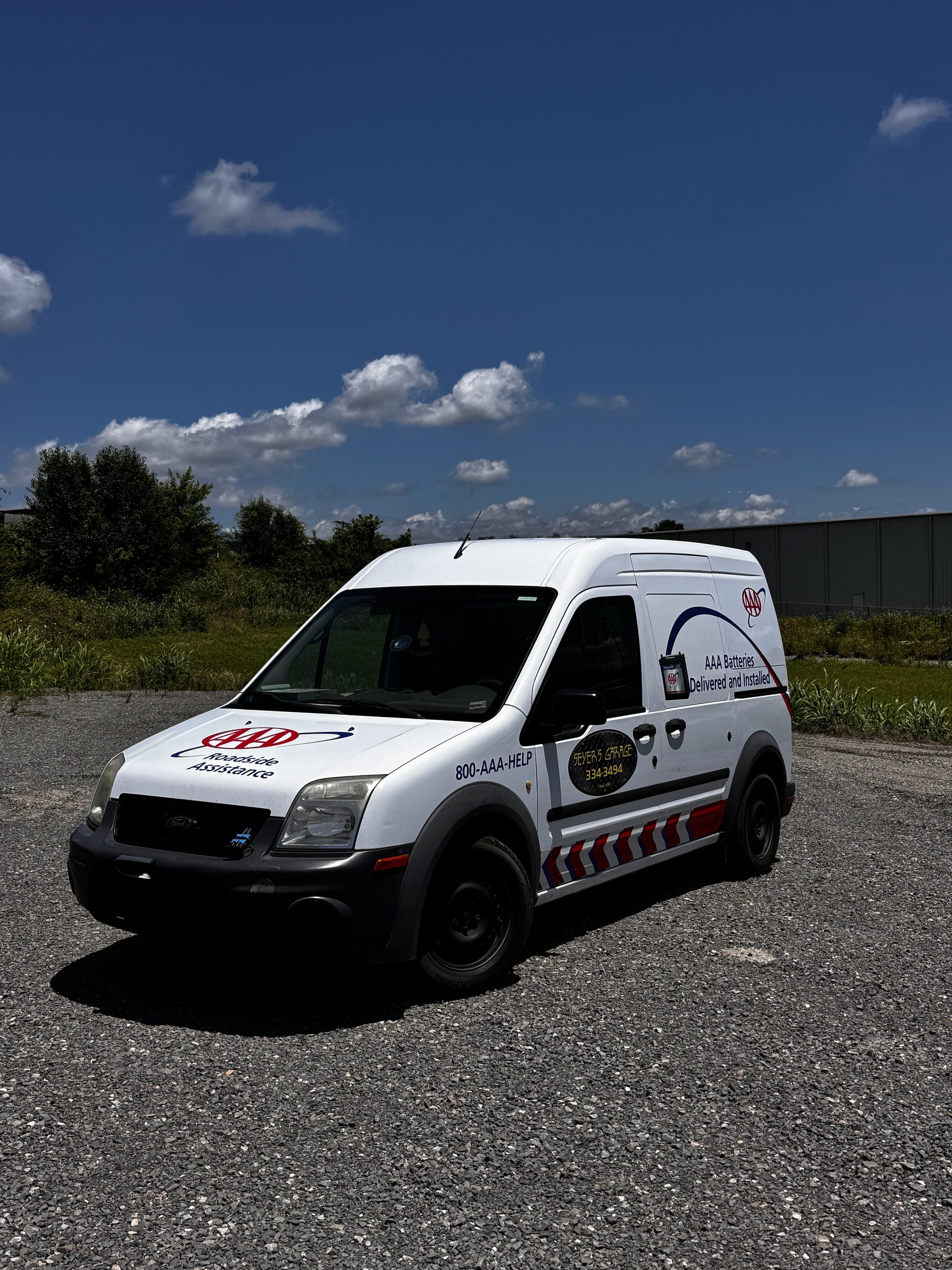 A white van is parked in a gravel lot on a sunny day. | Seyer Garage
