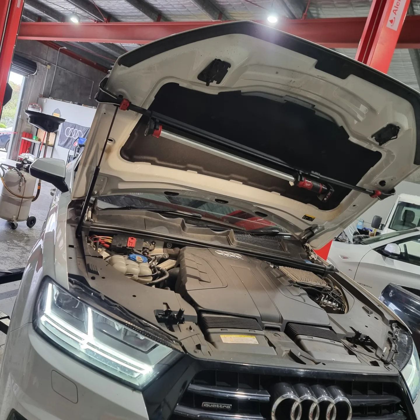 A silver Audi with its hood open in a garage. A mechanic likely working on the engine — MC Automotive Service & Repairs in Maitland, NSW