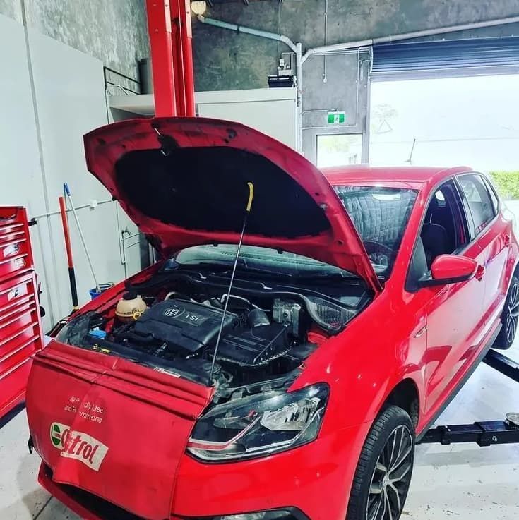 Red Car With Hood Open In A Garage On A Lift, Being Worked On — MC Automotive Service & Repairs in Maitland, NSW