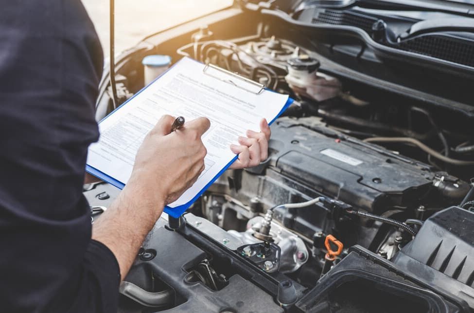 Mechanic Inspecting A Car Engine, Holding Clipboard And Pen, Outdoors — MC Automotive Service & Repairs in Maitland, NSW