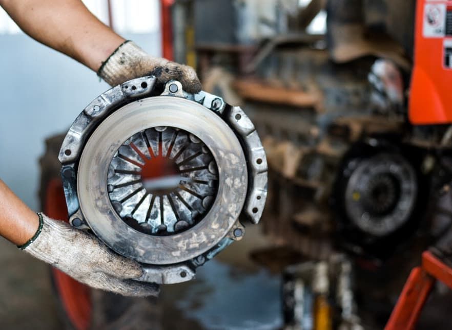 Mechanic Holding A Worn-out Tractor Clutch. Dirty Hands In Gloves — MC Automotive Service & Repairs in Maitland, NSW