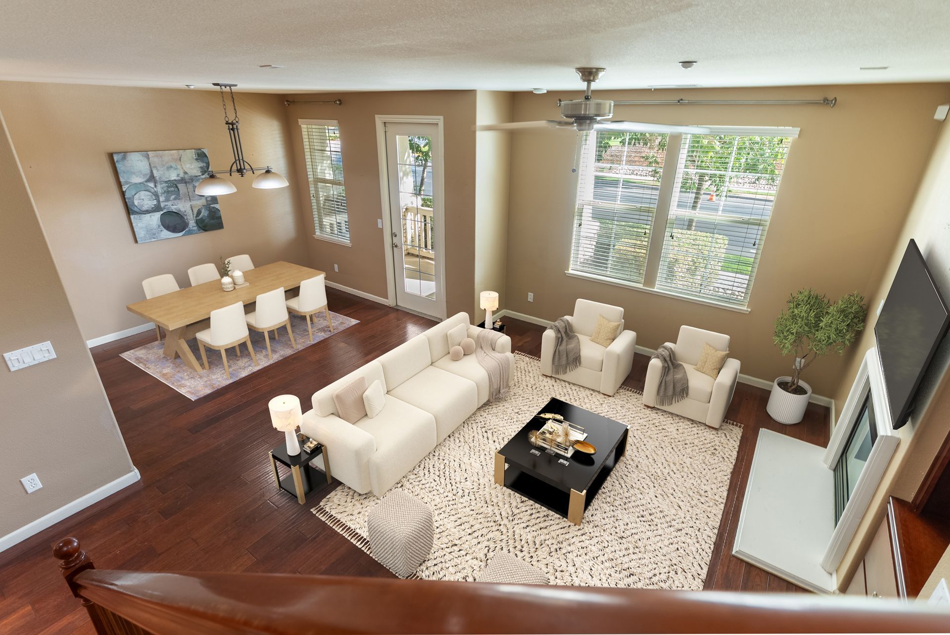Spacious living room with dining area, beige couches, black table, and large windows.