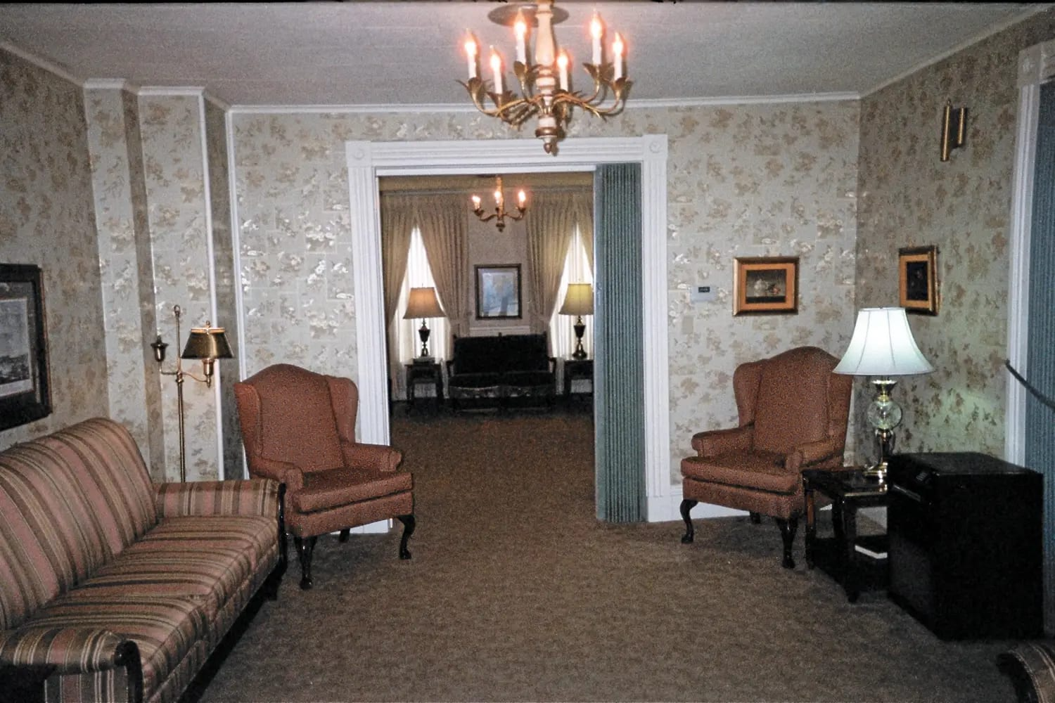 A living room with a couch and chairs and a chandelier