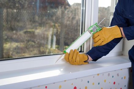 installing caulking on window ledge