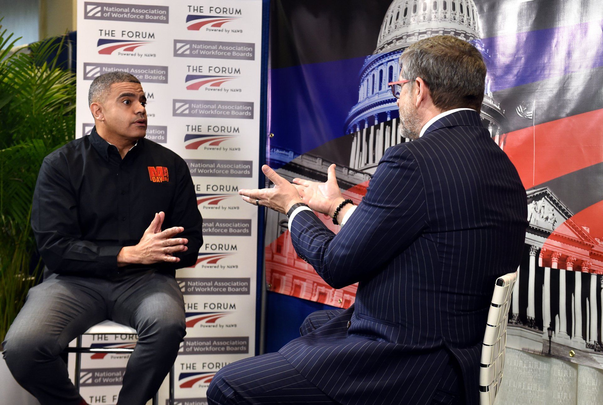 Two men are having a conversation in front of a capitol building.