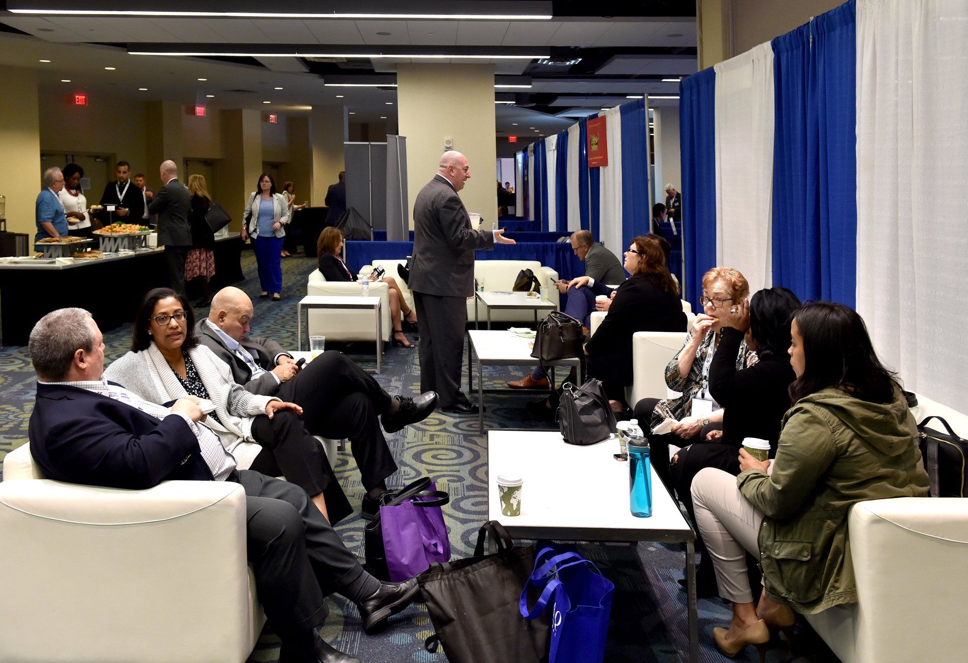 A group of people are sitting in a room talking to each other.