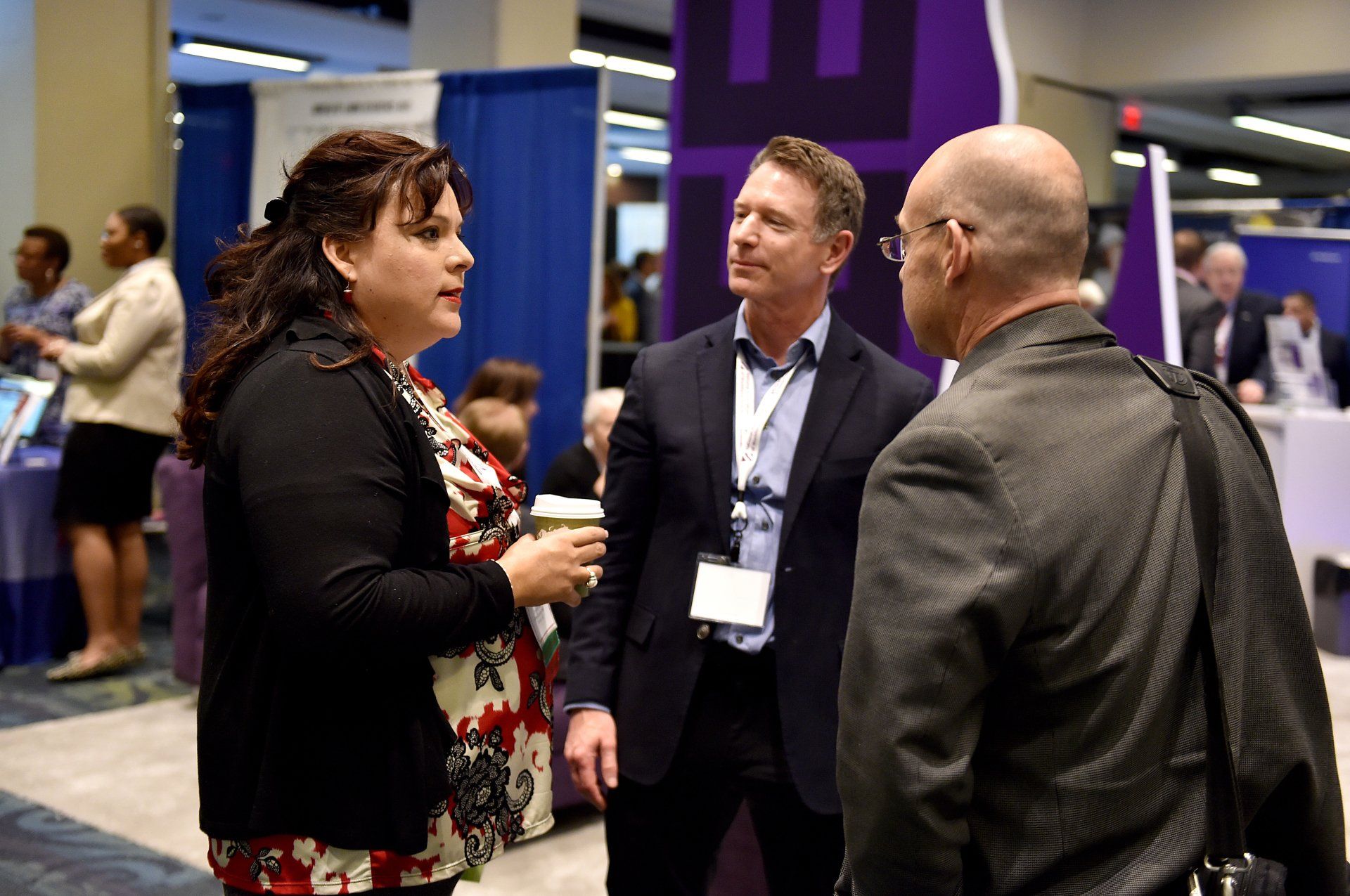 A group of people are talking to each other at a convention.