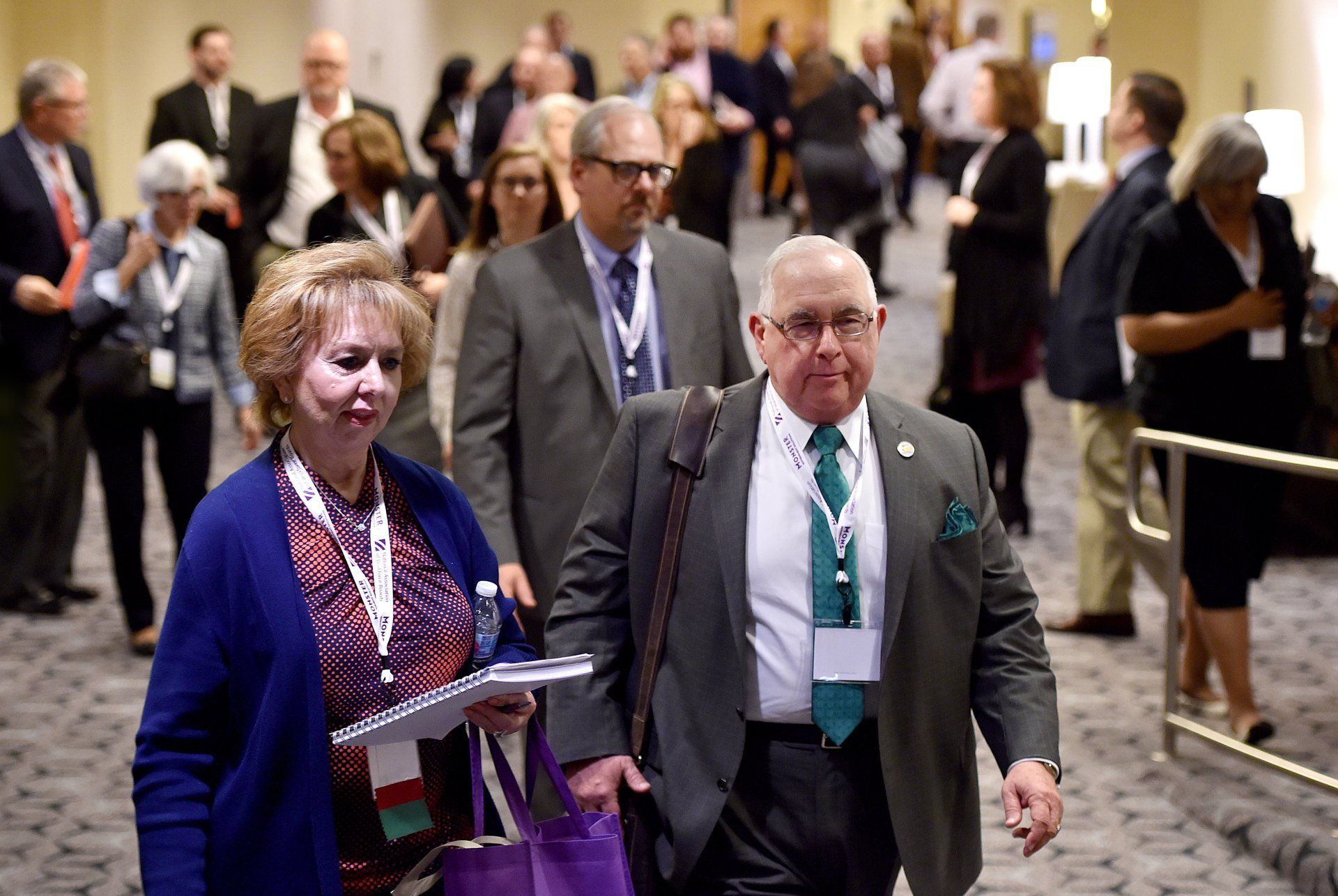 A group of people are walking down a hallway.