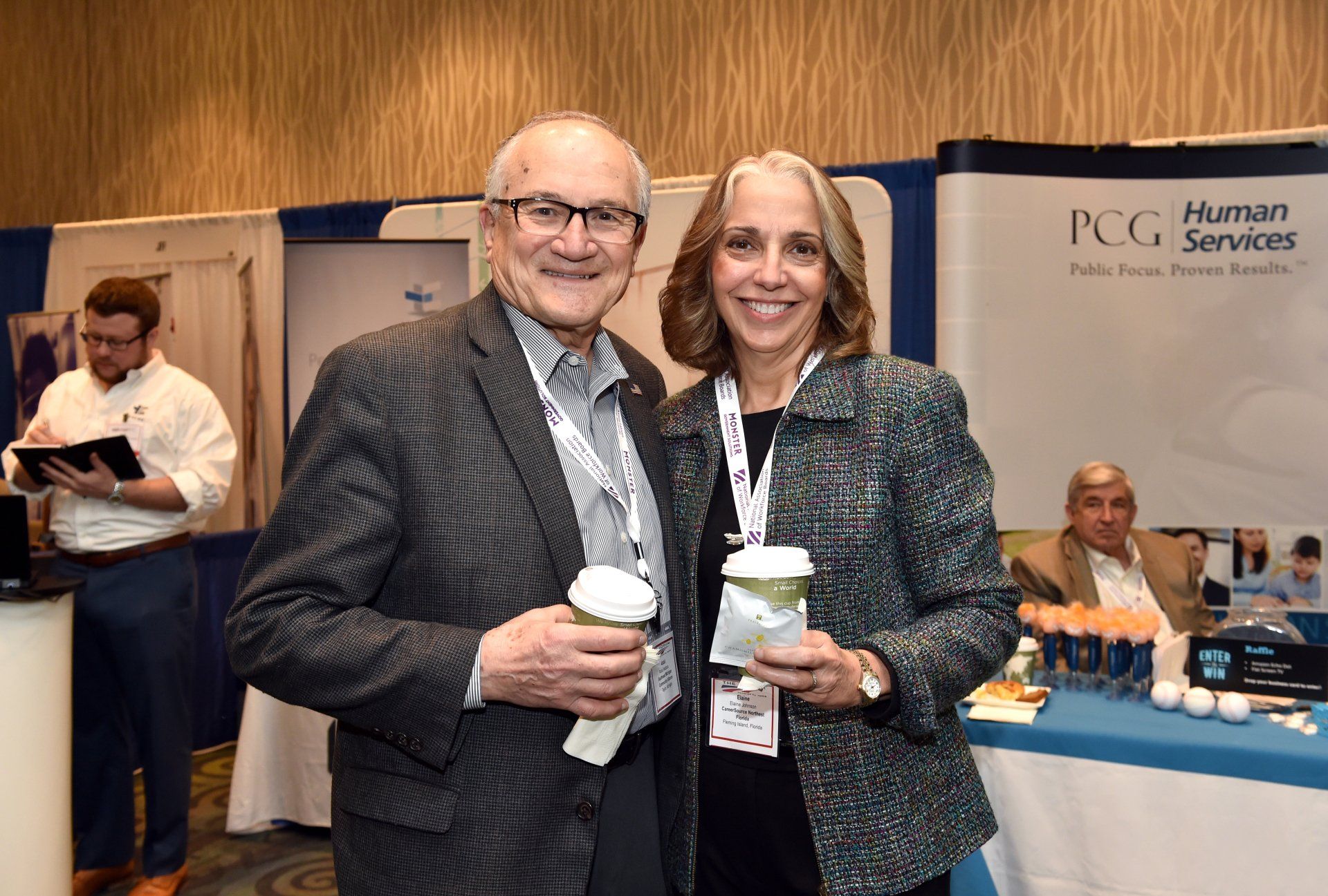 A man and a woman are posing for a picture at a conference.