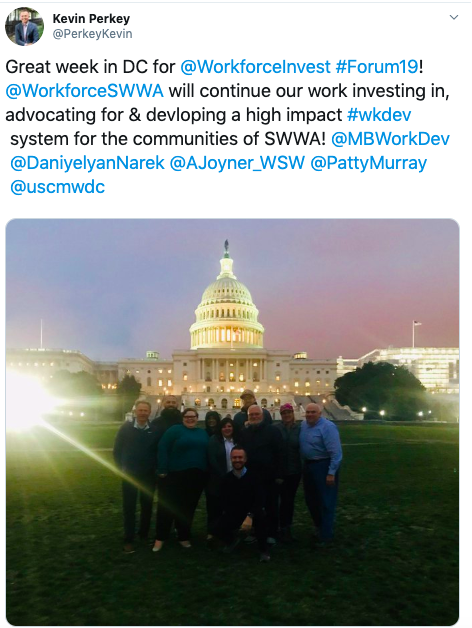 A group of people are standing in front of the capitol building.