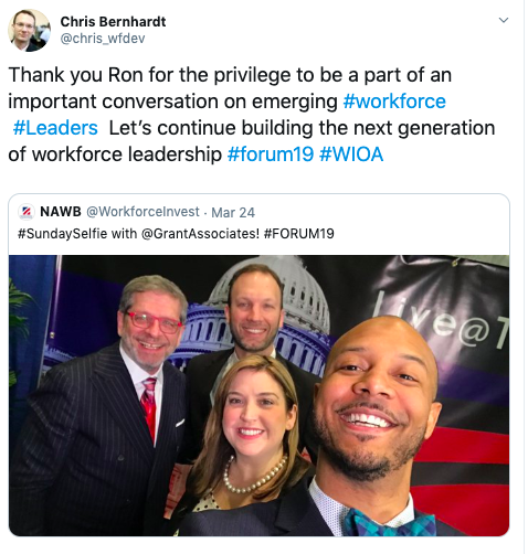 A group of people are posing for a selfie in front of a capitol building.