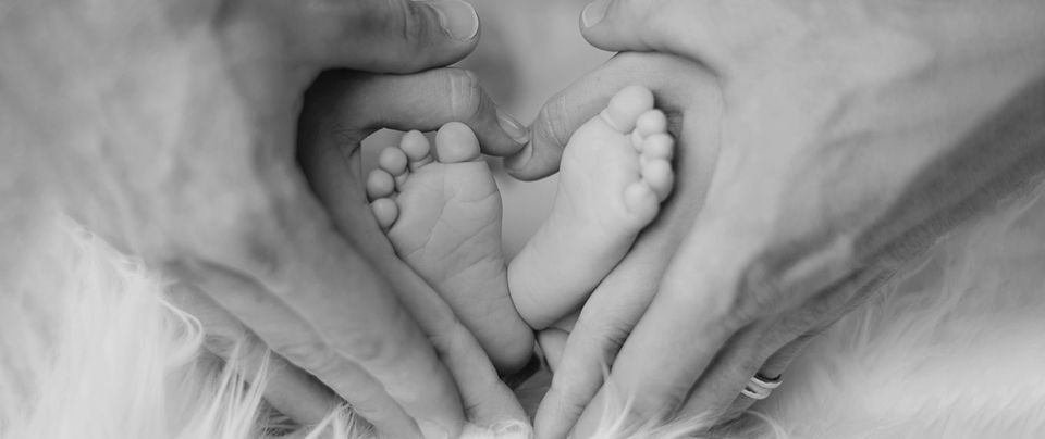 Parents hands cradling an infants feet