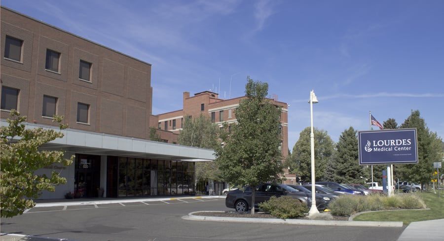 A large brick building with a parking lot in front of it.