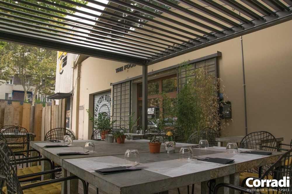 Ristorante con tavoli e sedie sotto un pergolato.