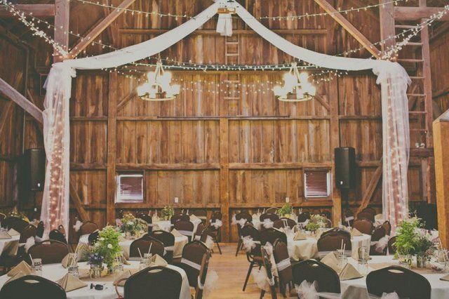 A room with wood walls is set up for a wedding reception.