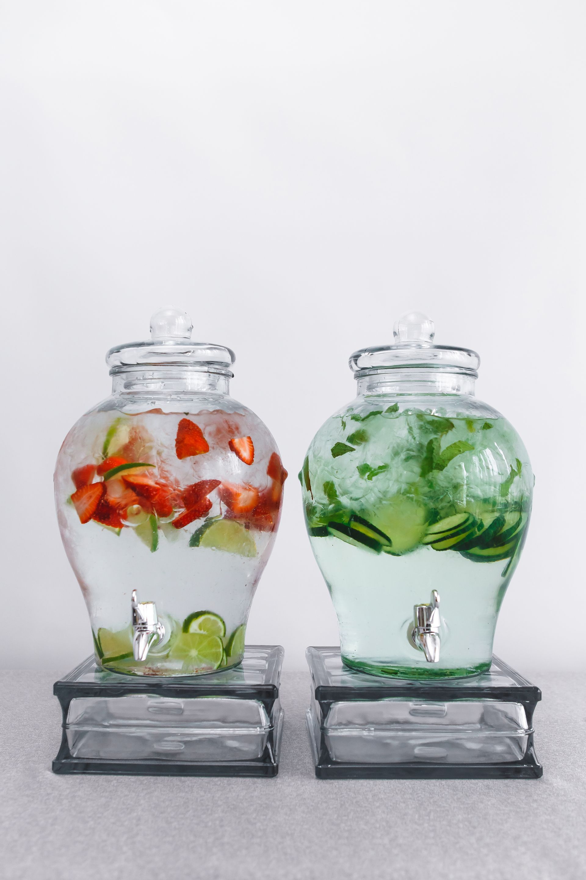 Strawberries and cucumber are in a glass jar of water.