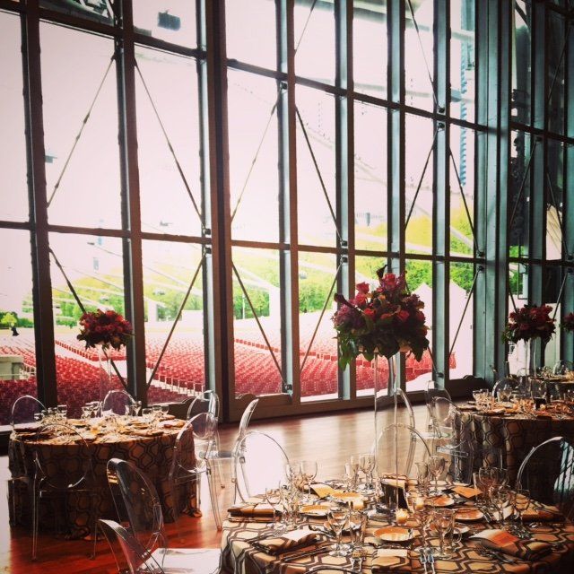 A large room with tables and chairs and flowers in vases