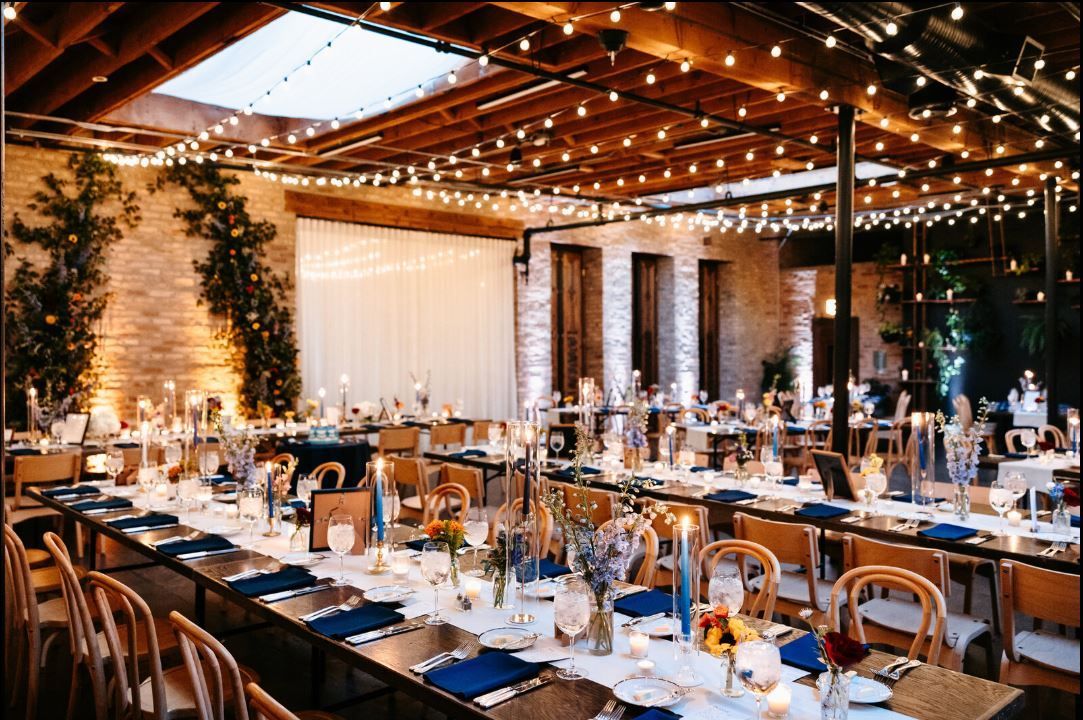 A long table with glasses of wine and flowers on it.