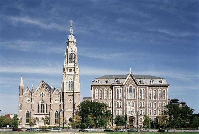 A large building with a clock tower next to a church