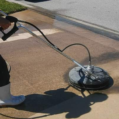Joes Window washing and pressure washing is using a pressure washer to clean a driveway .