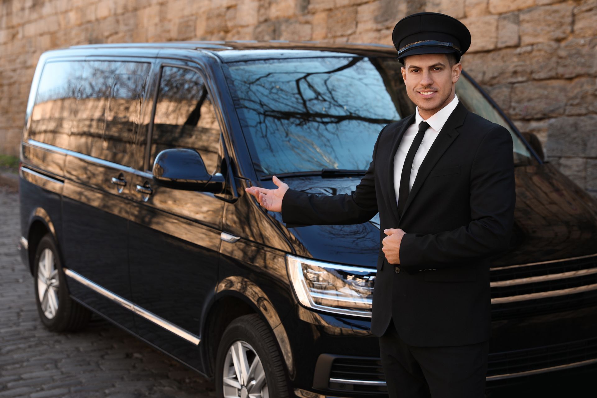 A man in a suit and tie is standing next to a black van.