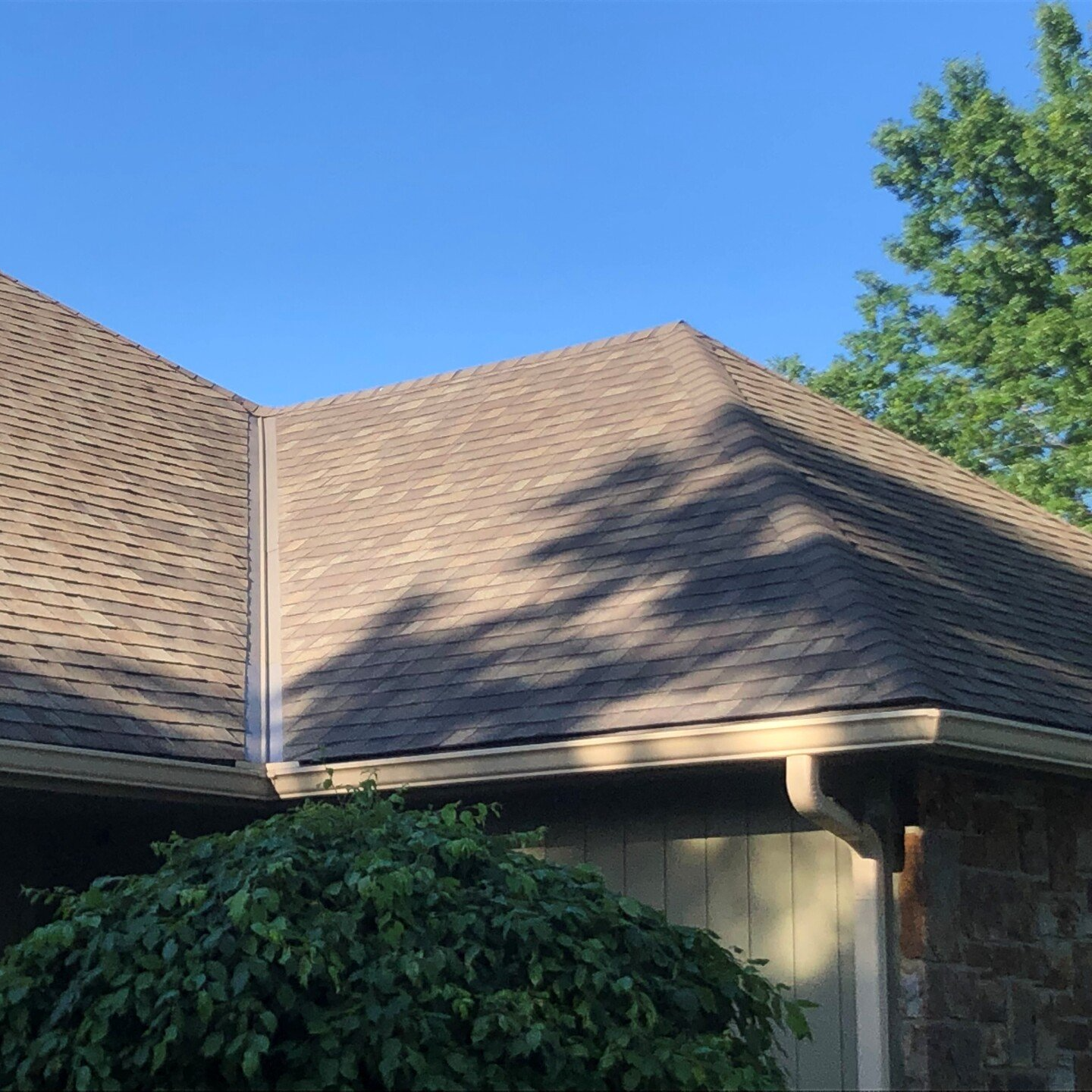green and brick home roof repair close up
